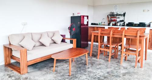 a living room with a couch and a table and chairs at Turtle House Surf & Stay in Airsatang