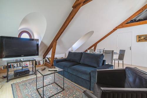 un salon avec un canapé et une télévision dans l'établissement Clocher de la Cathedrale de Reims, à Reims