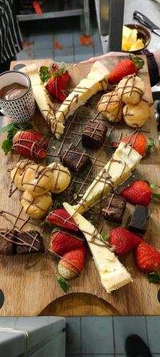 a wooden cutting board with desserts and strawberries on it at Great Trethew Hotel - Self Catering Lodges - Bar & Restaurant in Liskeard