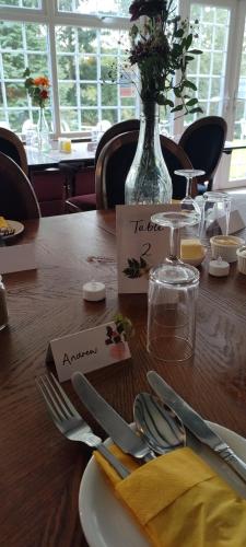 a wooden table with a plate and utensils on it at Great Trethew Hotel - Self Catering Lodges - Bar & Restaurant in Liskeard