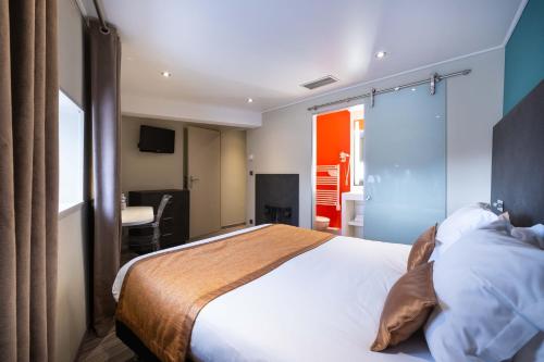 a bedroom with a bed and a room with a table at LOGIS Hôtel de Bourgogne - Mâcon in Mâcon