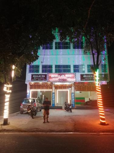 a man standing in front of a building at night at HOTEL AV Priya Rajgir in Rājgīr