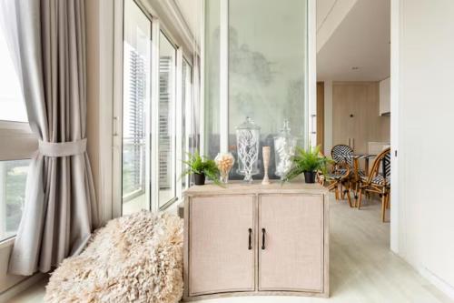 a living room with a cabinet in front of a window at Family Sea view 2Bedroom พร้อมครัว ติดทะเล at Veranda Pattaya in Na Jomtien