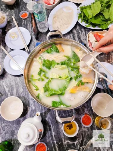 a pot of soup with vegetables in it on a table at Mossy Forest Family Retreat III, 2-8pax, Sunrise View, Cameron Highlands in Cameron Highlands