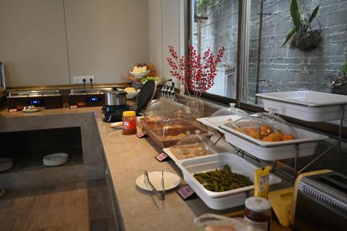 a kitchen with a counter with food on it at MIZPARTON HOTEL - Heshan Xinhua City Store in Jiangmen