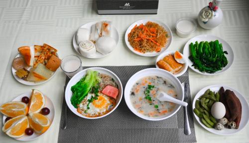 a table with plates of food and bowls of food at MIZPARTON HOTEL - Heshan Xinhua City Store in Jiangmen