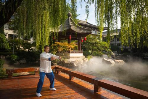 a man standing on a bench in front of a building at HUALUXE Xi'an Tanghua by IHG in Xi'an