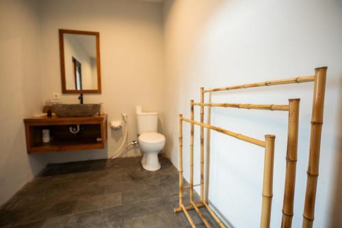 a bathroom with a toilet and a sink and a mirror at Skylake Villa in Kubupenlokan