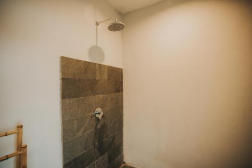 a bathroom with a stone wall and a shower at Skylake Villa in Kubupenlokan