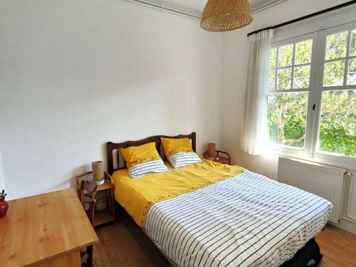- une chambre dotée d'un lit avec des draps jaunes et blancs dans l'établissement Charmante villa avec jardin clos, à 100m du Bassin d'Arcachon, proche plages et commerces, Wi-Fi - FR-1-736-47, à Lège-Cap-Ferret
