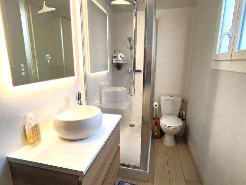 une salle de bain blanche avec un lavabo et des toilettes dans l'établissement Charmante villa avec jardin clos, à 100m du Bassin d'Arcachon, proche plages et commerces, Wi-Fi - FR-1-736-47, à Lège-Cap-Ferret