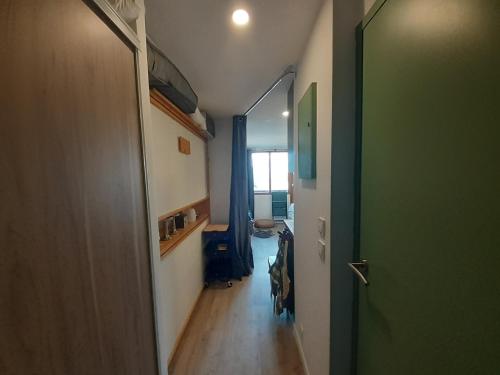 un couloir avec une porte menant à une chambre dans l'établissement Studio rénové à Valfréjus, proche télécabine et commerces - FR-1-561-134, à Modane