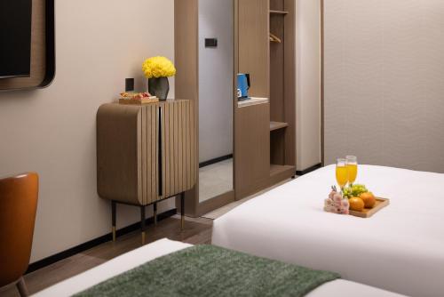 a hotel room with a bed and a table with fruit at Anya Hotel -Next to Jiefang West Bar Street 2 minutes to the subway station free coffee free laundry free gym, huge windows in Changsha