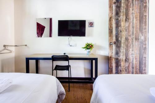 a desk with a chair in a room with two beds at Plumeria 4BR Garden House by uBook in Butterworth