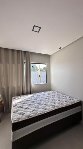 a bedroom with a large bed in front of a window at Mansão Moraes - em Itacimirim Linha Verde in Camacari