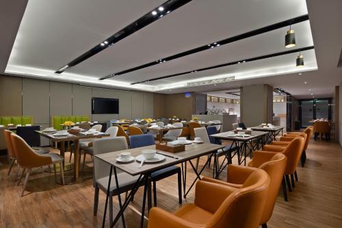 a large dining room with tables and chairs at Anya Hotel -Next to Jiefang West Bar Street 2 minutes to the subway station free coffee free laundry free gym, huge windows in Changsha