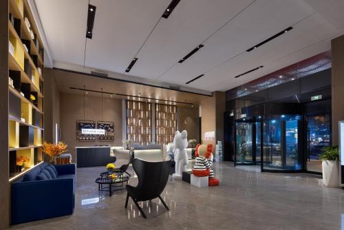 a lobby with couches and chairs in a building at Anya Hotel -Next to Jiefang West Bar Street 2 minutes to the subway station free coffee free laundry free gym, huge windows in Changsha
