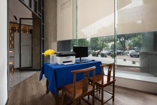 a blue table with a computer on top of it at Anya Hotel -Next to Jiefang West Bar Street 2 minutes to the subway station free coffee free laundry free gym, huge windows in Changsha
