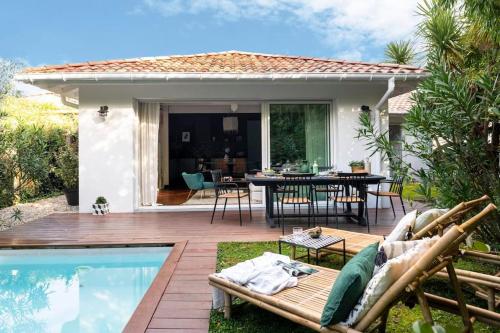 une cour arrière avec une piscine et une maison dans l'établissement TROPIQUE BASQUE, un air de Bali sur la côte basque, à Anglet