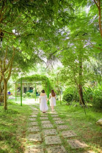 two women walking down a path in a park at Rafe Garden-Homestay Ba Vì in Ba Vì
