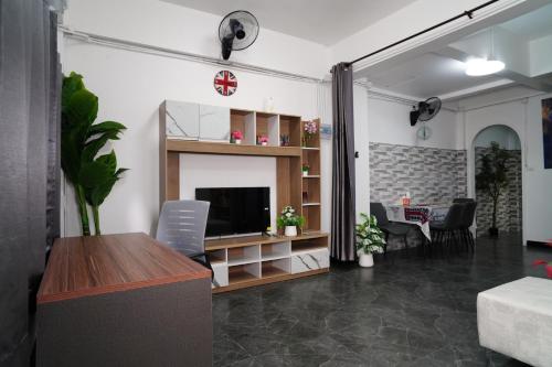 a living room with a flat screen tv and a couch at London House Phuket in Kata Beach