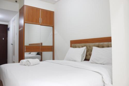 two beds in a hotel room with towels on them at Compact Studio Tamansari Panoramic Apartment By Travelio in Bandung