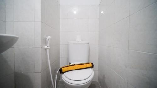 a bathroom with a white toilet with a yellow seat at Studio Apartment at Suncity Residence Sidoarjo near Suncity Mall By Travelio in Sidoarjo