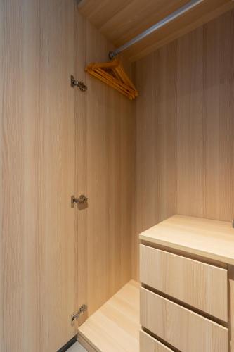 a walk in closet with wooden walls and wooden drawers at HALA Home Phú Quốc in Phu Quoc