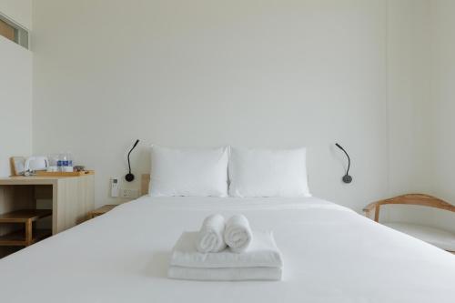 a bed with a pair of white shoes on it at HALA Home Phú Quốc in Phu Quoc