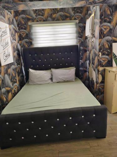 a bed with a black headboard in a room at Amaia Steps Altaraza by GEMcondotel in Tunkong Manga