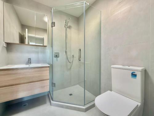 a bathroom with a shower and a toilet and a sink at Lake Quarter Apartment in Auckland