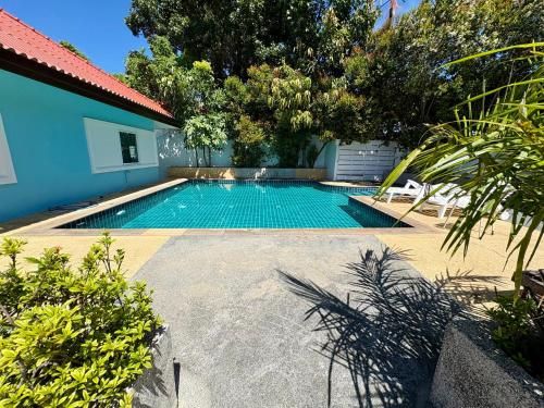a swimming pool in the middle of a yard at 2 bedroom bungalow Nai Harn 4 Resort in Ban Suan