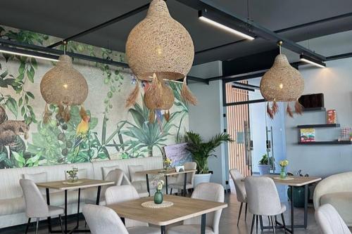 a restaurant with tables and chairs and a floral wall at Stylish apartment near the sea with direct pool access and top facilities in Ayios Nikolaos