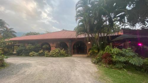 a house with a palm tree in front of it at Hotel Boutique Casona del Cafetal and Lakeside Restaurant in Cachí