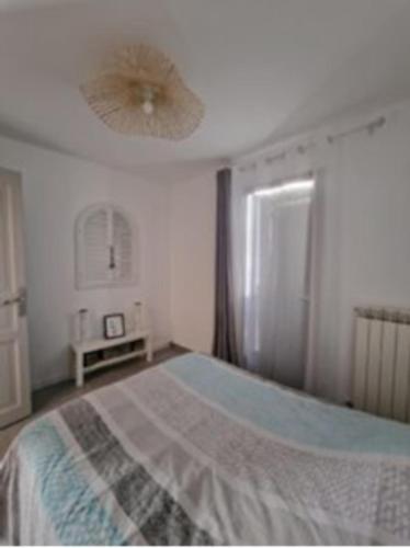 une chambre avec un lit et un ventilateur de plafond dans l'établissement Rez-de-jardin à 3 min à pied de la plage des Sablettes, à La Seyne-sur-Mer