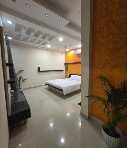 a bedroom with a bed and a plant in a room at Satyabhama HomeStay-Pearl-Luxury two BHK Appartment in Indore