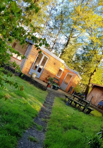 a wooden house with a picnic table in front of it at Knus huisje in het bos in Beekbergen