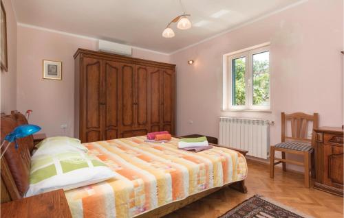 a bedroom with a large bed and a chair at Beautiful Home In Liznjan With Sauna in Ližnjan