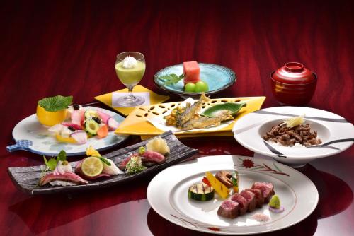a table with plates of food and a glass of wine at Ryuguden in Hakone