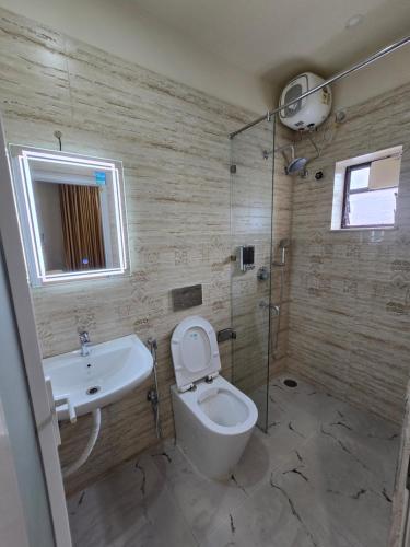 a bathroom with a toilet and a sink and a shower at Step Home in Kolkata