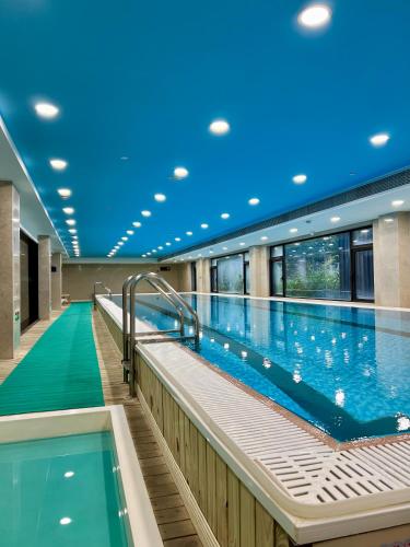einen großen Innenpool mit blauer Decke in der Unterkunft Shushe Hotel Shanghai in Shanghai