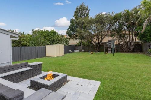 a backyard with a fire pit in the yard at Acacia Ridge Cottage - Firepit, Kids Cubby, Games in Brisbane