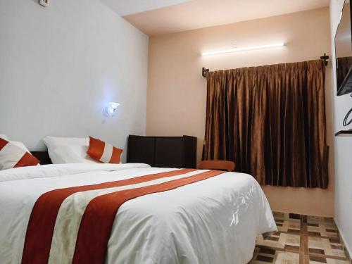 a hotel room with two beds and a window at Ponmurugan Residency in Kodaikānāl