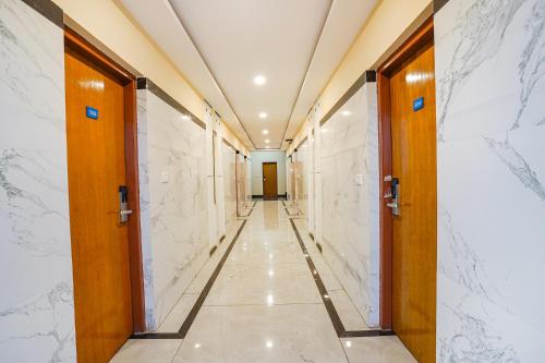 a corridor in a building with doors and marble walls at FabHotel Prime The Waves in Bengaluru