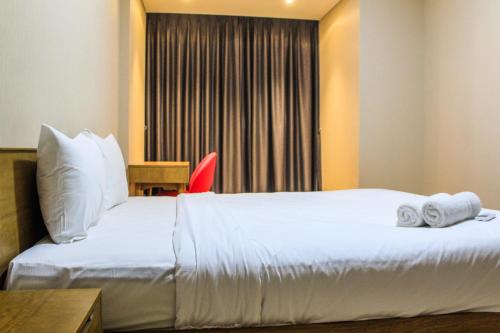 a hotel room with a bed with towels on it at Best View 1BR Apartment at Gold Coast PIK By Travelio in Jakarta