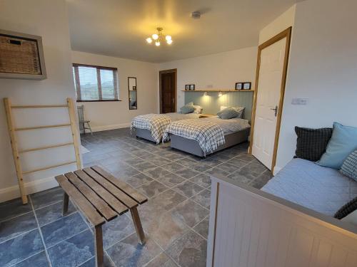 a room with two beds and a table and a couch at The Boat House in Adrigole
