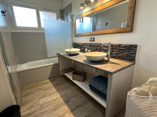 une salle de bain avec deux lavabos, un miroir et une baignoire dans l'établissement Maison 4 chambres avec jardin, à Mont-de-Marsan