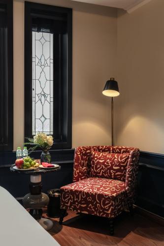 a chair in a room with a table and a window at Champton Hanoi Hotel in Hanoi