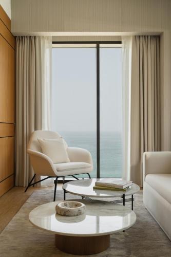 a living room with a couch and a chair and a table at Delano Dubai at Bluewaters in Dubai