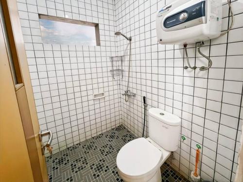 a small bathroom with a toilet and a window at Large Villa 3BR Dago Bandung by 2ndHome in Bandung